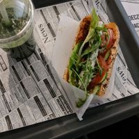 soy dog with chilli and garlic sauce and a green juice  at Farma Burgerownia Roslinna in Krakow