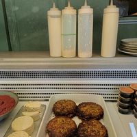The sauce in the bottle with the green ribbon is vegan at Falafel Factory in Copenhagen