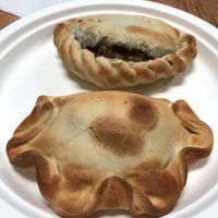 Lentil & quinoa empanada bursting open in back, special soy chorizo in front at World Empanadas in Burbank