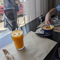 Fresh squeezed orange juice, hummus with rice pita chips, and Americano coffee at Veganaki in Athens