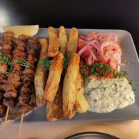 Souvlaki with baked potatoes, tzatziki and tomato salad at Veganaki in Athens