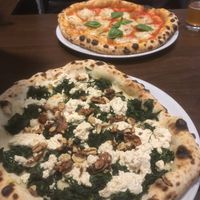 Pizza spinaci bianca and salami pizza in the background  at La Stella Nera in Berlin