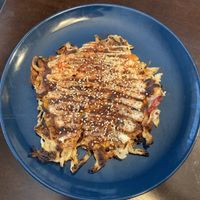 A cabbage & onion pancake with fried tofu, topped with house tonkatsu sauce, veganaise, house furikake, shichimi. house kimchi. at Obon Shokudo in Portland