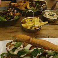 Mushroom Bánh Mi, Donner Kebab, and side dishes of fries, potato salad, and aubergine salad    at Super Natural Newcastle in Newcastle Upon Tyne