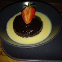 Sticky Toffee Pudding with Custard & a strawberry. at Super Natural Newcastle in Newcastle Upon Tyne