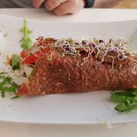 I don't remember the name, but the dough is like a pancake with lots of grains and inside hummus + salad at Rawdia in Brasov