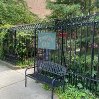 Exterior entrance, wrought iron gate and bench, sign reading IRON GATE CAFE at Iron Gate Cafe in Albany