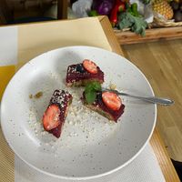 Exquisitely plated cake topped with fruit and mint and the coconut she hand-grated onto it.  at Happy Belly / Eat Smart in Tirana
