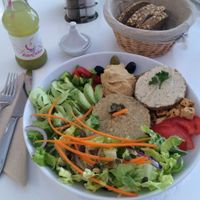 The "assiette vegan" with a variety of items, including a veggie burger (without bun), quinoa, salad and hummus. at Sweet Rawmance in Paris