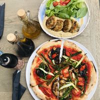 Vegan gourmet pizza and millet balls with hummus and salad dish at Manna Manna in Brasov