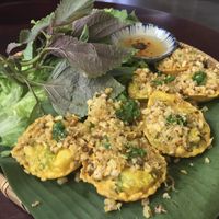 Banh Khot 
Vietnamese mini pancakes topped with mushrooms, scallions and with VEGAN fish sauce. 
Served with an assortment of greens.
This takes 20-25 minutes to prepare. at Pi Vegetarian Bistro in Ho Chi Minh City