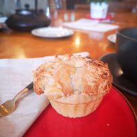 Picture of a frangipane cake on a red plate. The cake is in a pastry case and topped with flaked almonds at Planetwise & Yoga Studio in Bridlington