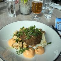 Green pea steaks served with braised pointed cabbage with yuzu and sesame, salt-baked celeriac, spring onions and chili emulsion – 199 SEK  at Torekov Hotel Bistro in Torekov