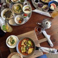 Lebanese breakfast (top left), Moroccan breakfast (top right), vegan shakshuka with zucchini and olives (bottom) at Shuk in Warsaw