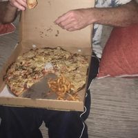Not the best pic 🤣this is my dad enjoy his pizza with Curley fries 💚 at Mr Singh's in East London