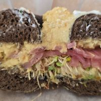 Toasted Rye (was actually pumpernickle) Bagel with hummus, Sprouts, Pickled Red Onion had to be remade because it got cut with a knife that left a cream cheesesmear on vegan order at Bagel Cafe in Camden