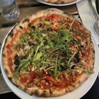 Pizza vegana: queso vegano, pollo vegano, aceitunas, champiñones, pimiento, cebolla y rúcula  at Bella Sydhavn Pizzeria in Copenhagen