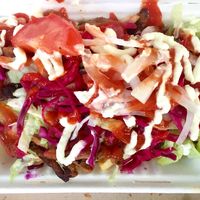 The Doner kebab and chips in a box covered with salad and sauces at What The Pitta in London