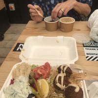 Mezze box (with half a falafel eaten) and falafel and hummus in pots  at What The Pitta in London