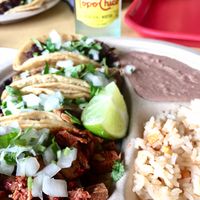 Four tacos, beans, and rice at El Palote Panaderia in Dallas