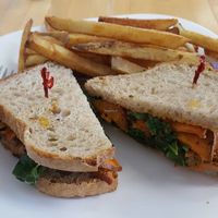 BBQ tofu sandwich with sweet potato medallions, kale and mayo on sourdough bread, with a side of fries.  at Grow Your Roots Cafe in Ottawa