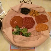 The two vegan dishes (see menu photo for details) served together on one injera. The container at left holds more of the "chouro" dish. Not shown is the additional bread this comes with. at Menelik in Paris