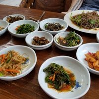 Tomato noodles and side dishes at Jayeonneuro in Jeju
