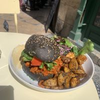 Bad boy burger (charcoal bun with avocado, tomato, roasted aubergine in bbq sauce with a side roasted potato, salad, hummus) at Kitchen Garden in Bordeaux