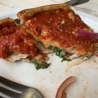Topping under sauce, cheese onions spinach  at Patxi's Pizza in Santa Barbara