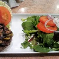 Vegan (Impossible) Build-A-Burger with side upgraded to a green salad. Fixings on burger were tomato, lettuce, Jalapeno, red onions, and sauteed mushrooms. About $15 plus. at Wild Flower Cafe in Red Hook