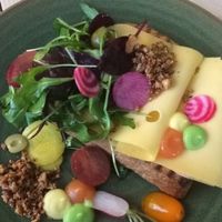 A delicious whole wheat piece of bread with cheese, greens and nuts. at Bij Albrecht in Eindhoven
