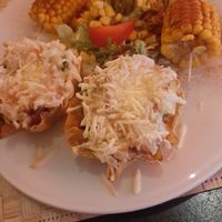 Hoofdgerecht: Tostada Toledo (?)  Gevuld met rijst, bonen, tomaat, avocado. Met vegan kaas, salade, guacamole, en maïskolven at Yucatan in Leeuwarden