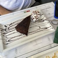 Torta caprese vegana servita con panna montana vegetale (with no cherry jam)  at Origano Campo de' Fiori in Rome