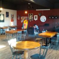 Cafe setting, local artist work on walls for sale, stage for events at Black Sheep Lounge in Welland