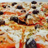 Specifically named vegan pizza has olives, oregano, fresh tomato and vegan cheese at Allambie Pizza Shop in Allambie Heights
