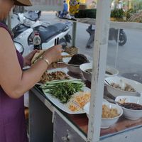 Owner preparing a banh mi at Hoi Banh My Chay - Food Stall in Hoi An