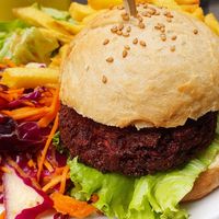 Beet burger served with fries and salad at Primeur Cantine in Paris