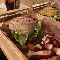 The limited edition Elf burger and Patatas Bravas (wedges with spicy sauce and vegan mayo) at Flower Burger in Rome