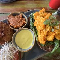 Corn fritter, almond tomato pesto, sweet potato tofu scramble on sourdough with spinach, cashew hollandaise   at Bali Bagus Cafe in Byron Bay