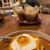 Francesinha comes with beautiful herbie fries! The sauce was amazing!!! at Outro Lado in Faro