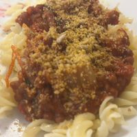 Lentil bolognese with GF pasta and homemade Parmesan .  at Outro Lado in Faro