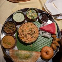 brunch thali (from left to right) :  capsicum curry,  okra fry, coconut chutney,  south Indian style salad,  halwa, assorted pakoras , mint dosa,and in the center vegetable biryani at Copper Bowl in Esslingen