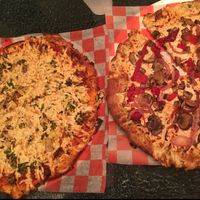 Two pizzas with vegan cheese, one with rosemary herb crust and the other with firecracker crust at Pizza Studio in Baltimore