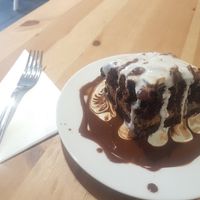 Chocolate and peanut cake with lashings of cream and chocolate sauce! at Holy Cow in Edinburgh