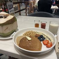 Fresh coconut and fruity pancakes with granola, maple syrup, strawberry sauce and soy milk #Veganuary at Veganerie - Ratchathewi in Bangkok