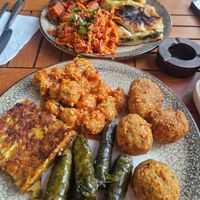 Front plate has falafel, stuffed vine leaves, courgette fritter and some bulgar meatballs, back plate has borek, bulgar salad, Seitan and cabbage rolls at Vegan Istanbul in Istanbul