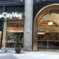 Restaurant store front and the lobby next door with cafe tables inside at HipCityVeg - Broad St in Philadelphia