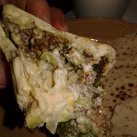 An up-close of the falefal sandwich with pickled turnips, onion, lettuce, think sauce, falafels, hummus, and pita at Saca's Mediterranean Cuisine in Claremont
