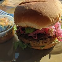 Homemade burger with spicy cucumber side at NU Kitchen in Somerville
