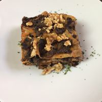 Vegan  bran lasagna with pumpkin béchamel, mushrooms, radicchio and topped with walnuts at Giardino Tergesteo in Trieste